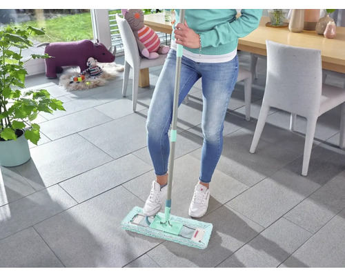 Vrouw dweilt tegelvloer met een mop