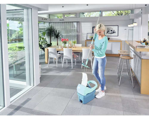 Vrouw dweilt vloer met een vloerdweilsysteem in een lichte kamer