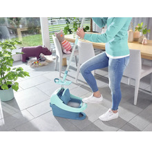 Vrouw gebruikt een mop en een emmer om de vloer schoon te maken.