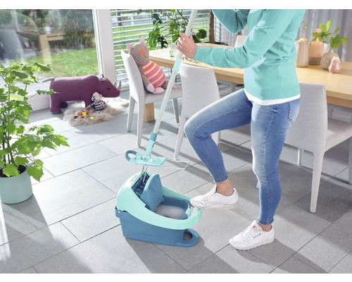 Vrouw gebruikt een mop en een emmer om de vloer schoon te maken.