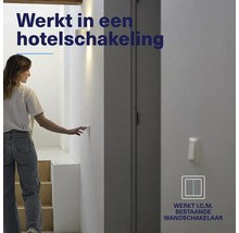 Vrouw bedient een lichtschakelaar aan de muur