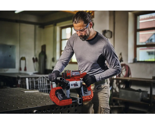 Man snijdt metaal met een Einhell accu bandzaag in een werkplaats