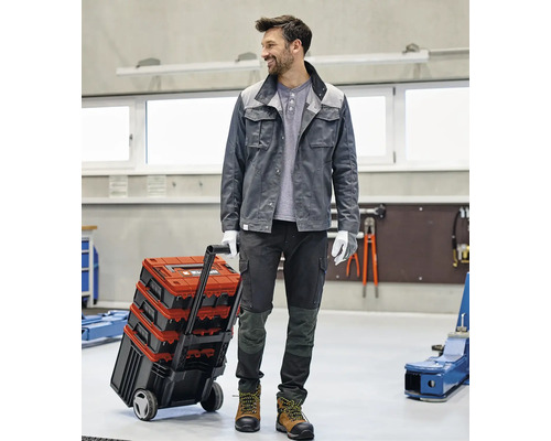 Ambachtsman met gereedschapskoffer op wielen in een werkplaats