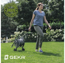 Vrouw trekt een tuinslangwagen van Geka over het gazon