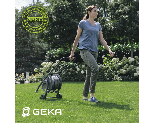 Vrouw trekt een tuinslangwagen van Geka over het gazon