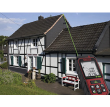 Een laser afstands meter meet de dakhoogte van een huis