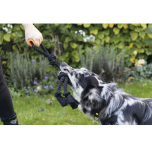 Persoon en hond spelen met een touwspeeltje met handvat