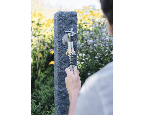 Tuinkraan met waterkraan en slangaansluiting wordt gemonteerd.