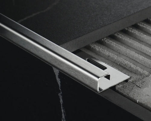 Tegelrail van metaal tussen twee tegels