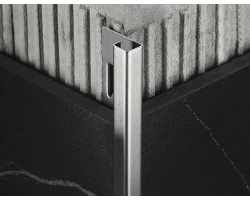 Detailopname van een metalen tegelprofiel op een hoek tussen twee tegels