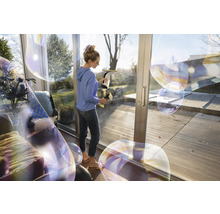 Vrouw reinigt ramen met een raamzuiger voor streeploze reinheid.