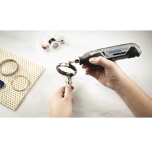 Dremel Logo. Iemand polijst een armband met een Dremel multi-tool.