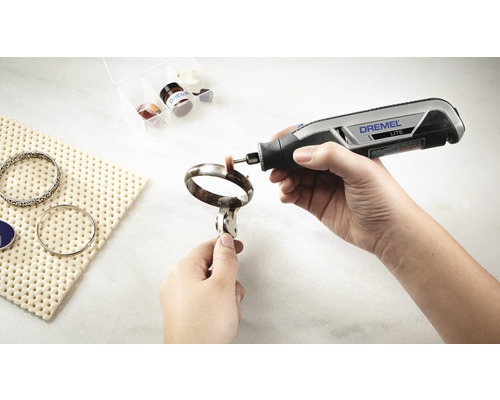 Dremel Logo. Iemand polijst een armband met een Dremel multi-tool.