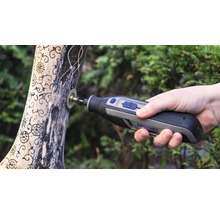 Dremel multifunctioneel gereedschap in gebruik op een stuk hout met gravures