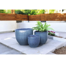 Drie plantenbakken van verschillende groottes op een terras