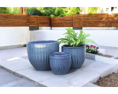 Drie plantenbakken van verschillende groottes op een terras