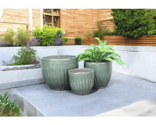 Drie keramische plantenbakken op een terras
