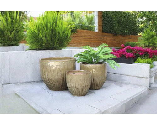 Scène met drie keramische bloempotten in de tuin