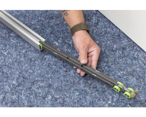 Schuifdeurbeslag met geleiderail in de hand