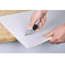 Een gipsplaat snijden met een mes.