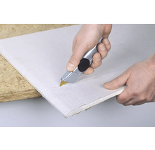 Persoon snijdt gipsplaat met een stanleymes