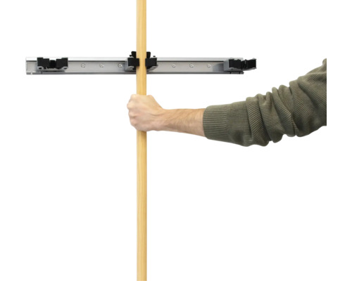 Man bevestigt steel in wandhouder voor gereedschap