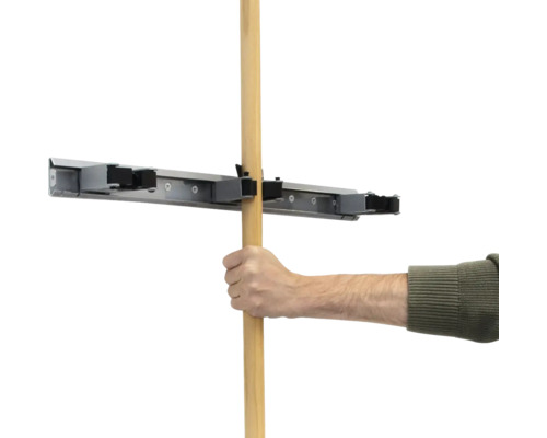 Een hand steekt een houten steel in een gereedschaphouder.