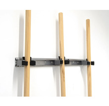 Gereedschapshouder met houten stelen aan een muur