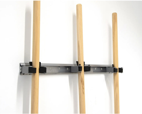 Gereedschapshouder met houten stelen aan een muur