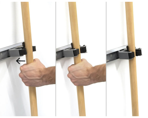 Afbeelding van een gereedschapslijstsysteem in gebruik, met een hand die een houten steel ophangt