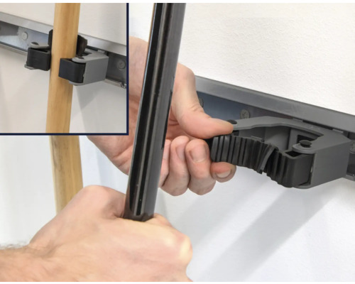 Wandhouder met hand die een steel vastmaakt