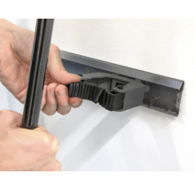 Persoon bevestigt een gereedschap aan een gereedschapshouder aan de wand.