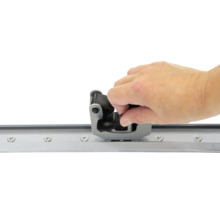 Hand monteert een schuifdeurgeleider op een rail