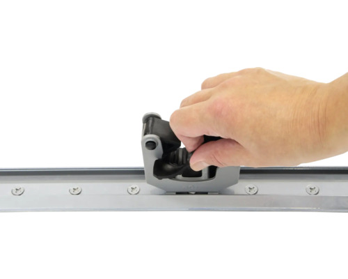 Hand monteert een schuifdeurgeleider op een rail
