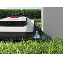 Robotmaaier op gazon in de buurt van een muur