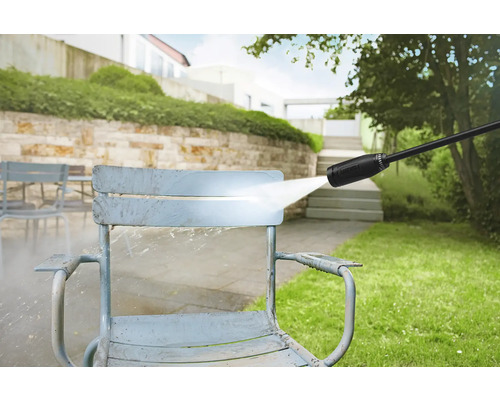 Hogedrukreiniger in gebruik voor het reinigen van een tuinstoel