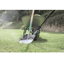 Schoonmaken van een spade met een hogedrukreiniger naast een kruiwagen in de tuin