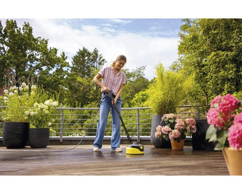 Vrouw maakt terras schoon met een terrasreiniger.