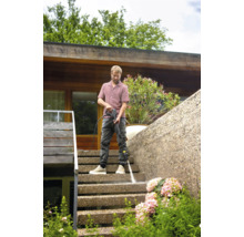 Man reinigt trap met hogedrukreiniger buiten.