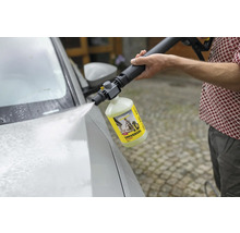 Iemand gebruikt een Kärcher universele reiniger met een hogedrukreiniger om een auto te wassen.