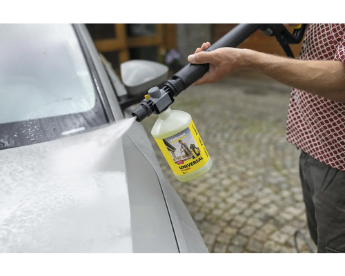 Iemand gebruikt een Kärcher universele reiniger met een hogedrukreiniger om een auto te wassen.
