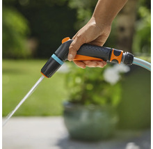 Een hand houdt een Gardena tuinspuit vast waar water uitkomt.