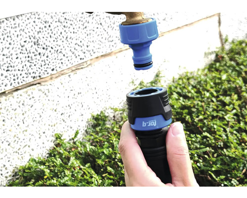 Tuinslangkoppeling wordt aangesloten op een waterkraan