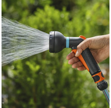 Een hand houdt een tuinsproeier vast waar water uitkomt.