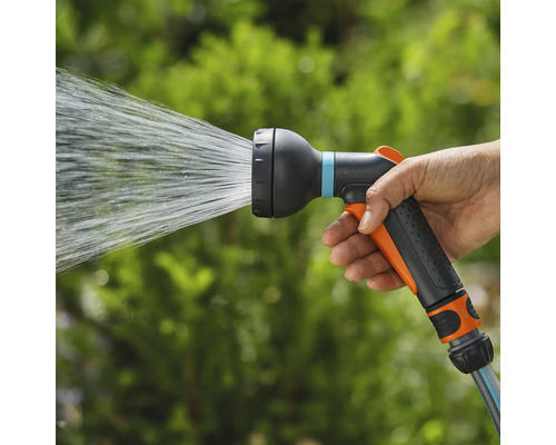 Een hand houdt een tuinsproeier vast waar water uitkomt.