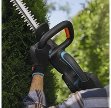 Persoon snoeit heg met Gardena accu heggenschaar