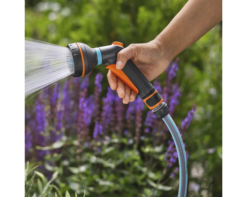 Tuinsproeier met waterstraal in de hand