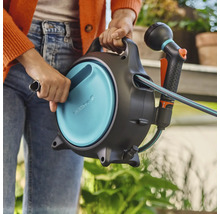 Tuinslangbox met slang en spuit in de hand