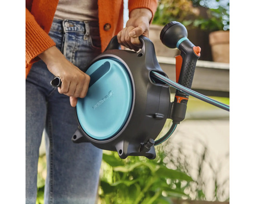 Tuinslangbox met slang en spuit in de hand