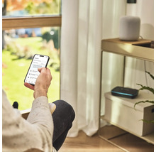 Een persoon bedient een tuinbewateringsapp op een smartphone